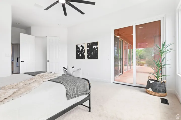 Master bedroom bedroom with an ensuite bathroom and glass sliding doors leading to a covered patio with serene pond views, creating a tranquil retreat.