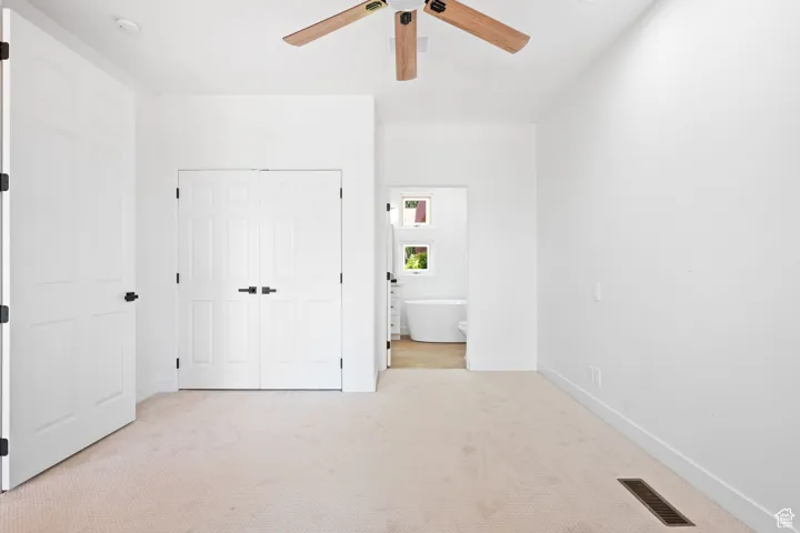 Guest bedroom with an ensuite bathroom and glass sliding doors leading to a covered patio with serene pond views, creating a tranquil retreat.
