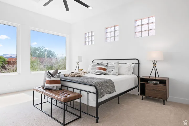 Master bedroom with two large picture windows overlooking the pond, a spacious walk-in closet, an ensuite bathroom, and access to the covered patio.