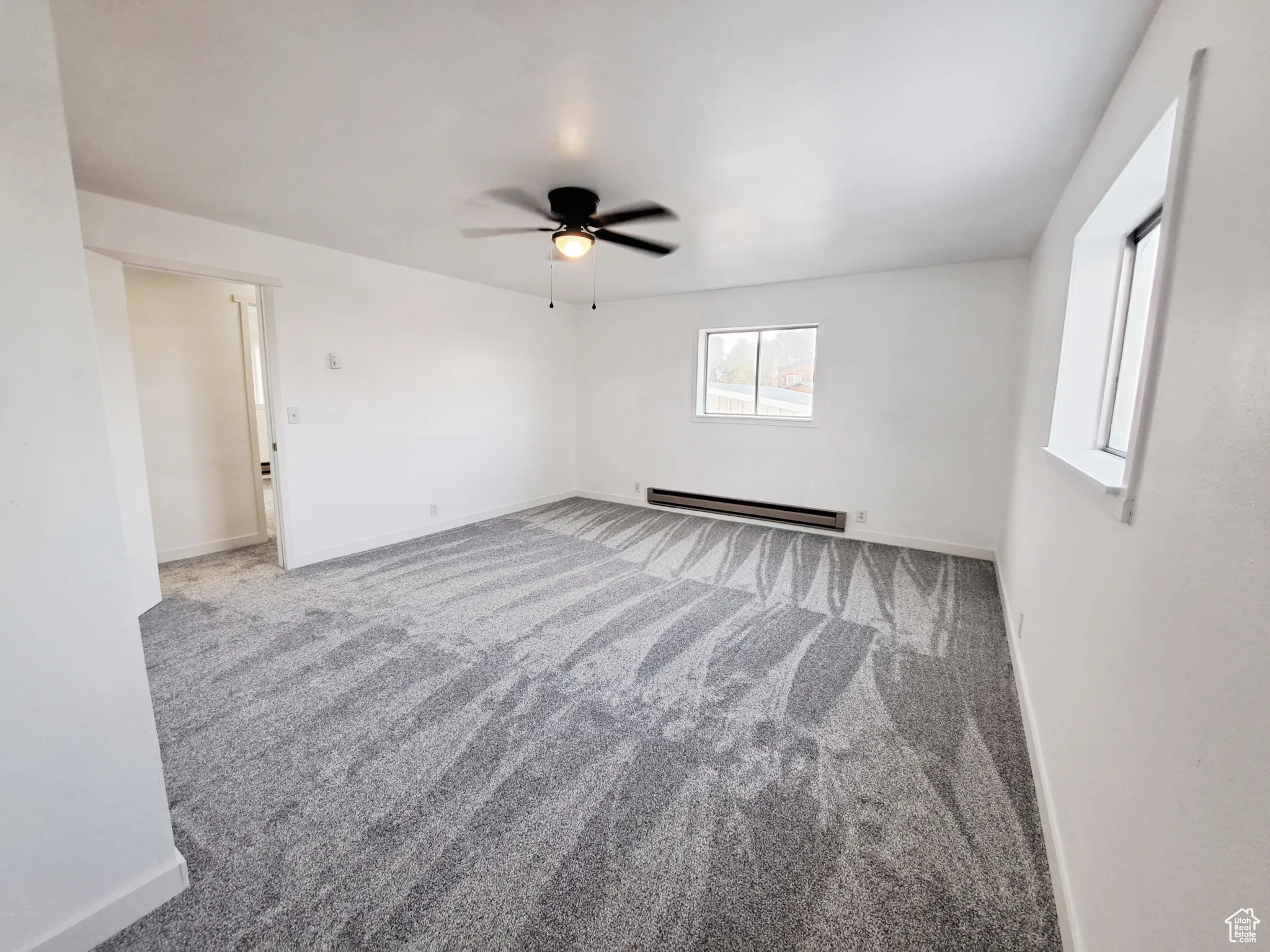 Bedroom 3, with New Windows, New Paint, New Doors, New Carpet, with a baseboard heating unit, plenty of natural light, and New ceiling fan.