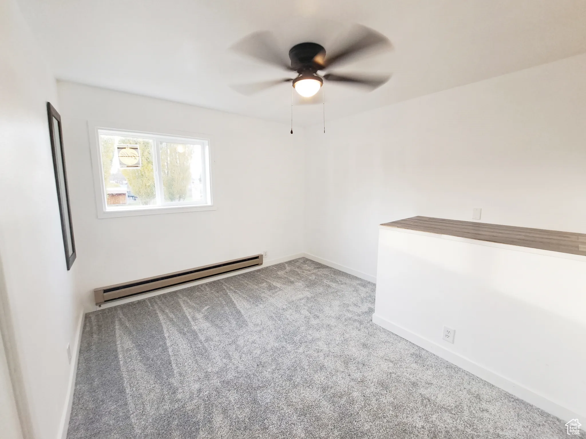 Bedroom 3, with New Windows, New Paint, New Doors, New Carpet, with a baseboard heating unit, plenty of natural light, and New ceiling fan