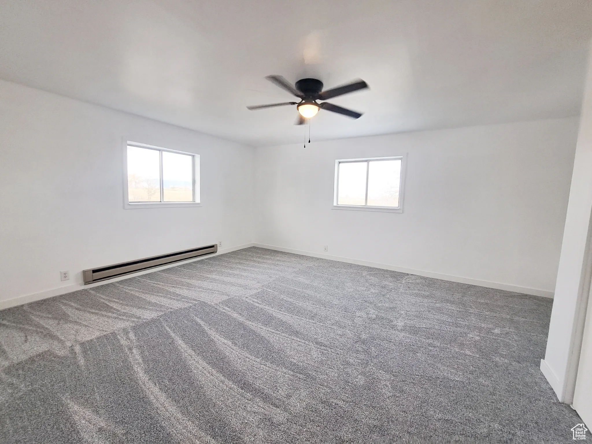 Bedroom 3, with New Windows, New Paint, New Doors, New Carpet, with a baseboard heating unit, plenty of natural light, and New ceiling fan