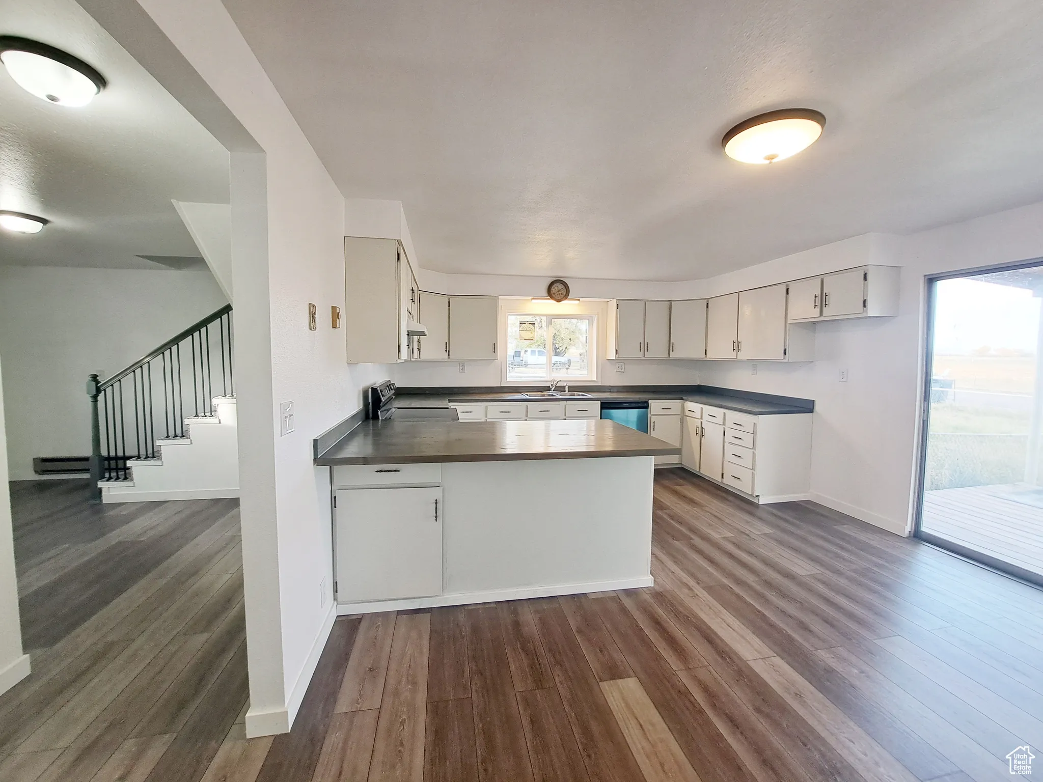 Kitchen with kitchen peninsula, New LVP flooring, a healthy amount of sunlight, Butcher Block Countertops, and sink