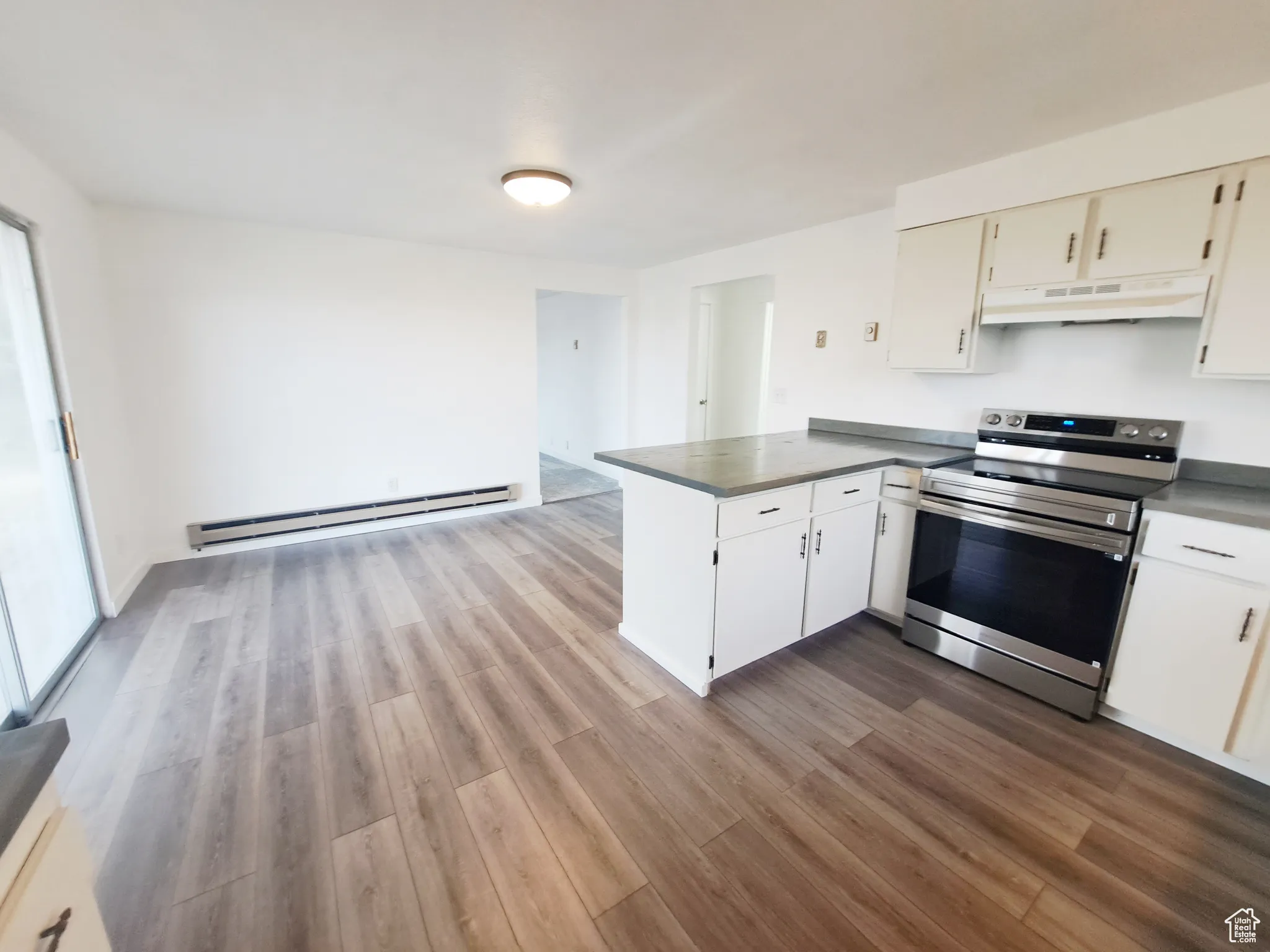 Kitchen featuring kitchen peninsula, stainless steel stove, New LVP flooring, New Appliances, New Paint, New Butcher Block Countertops