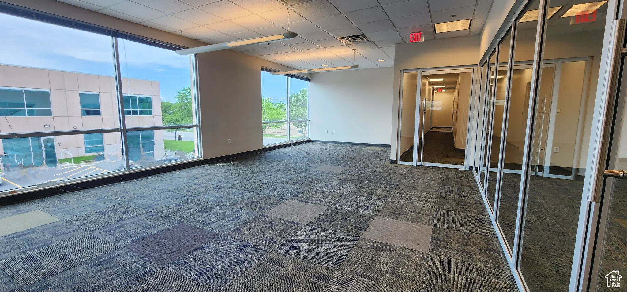 Interior space featuring dark carpet and a paneled ceiling