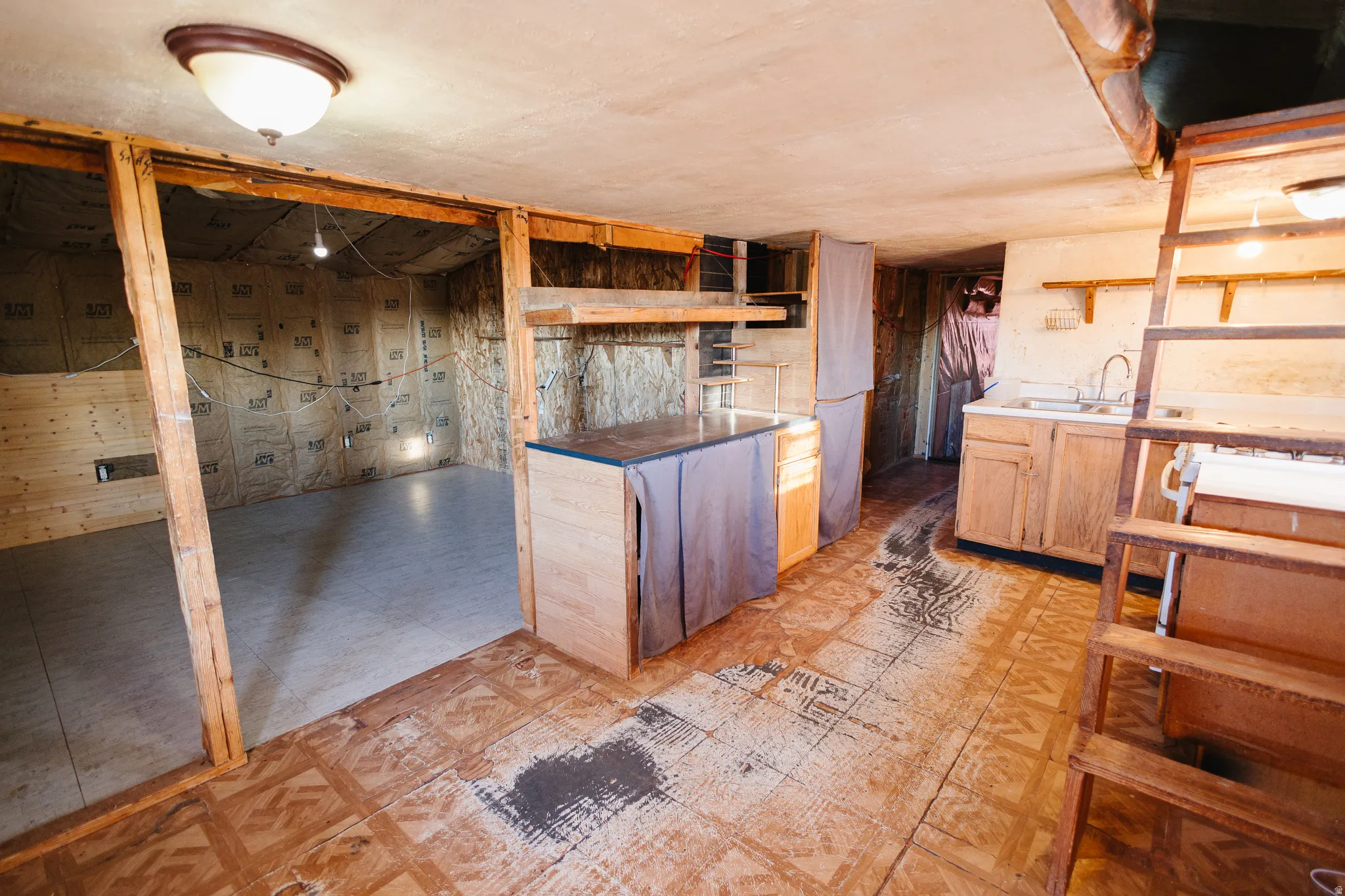 Kitchen featuring open shelves, light flooring, light brown cabinetry, and light countertops