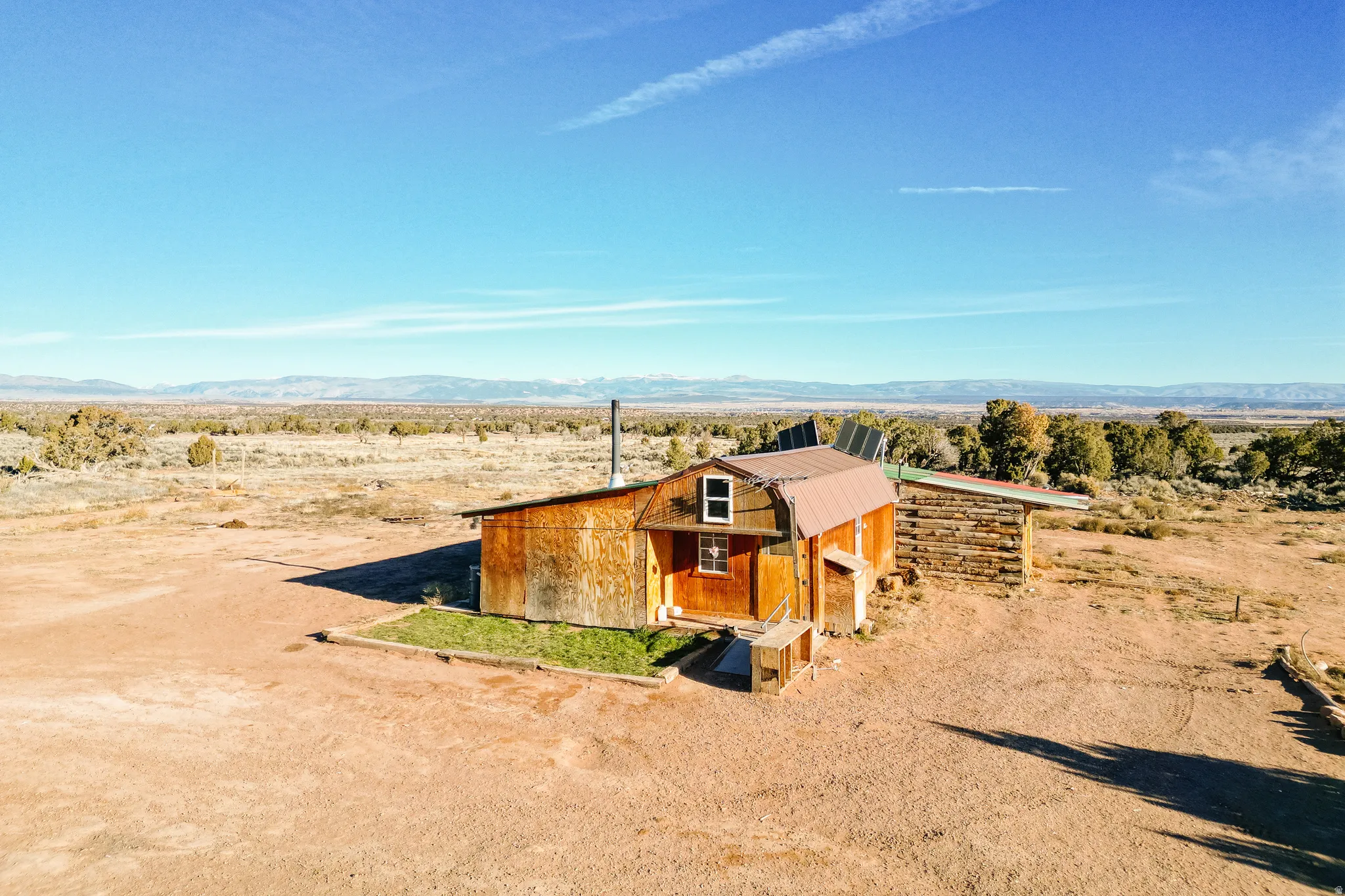 View of front of home with a mountain view, a metal roof, a view of rural / pastoral area, and an outbuilding