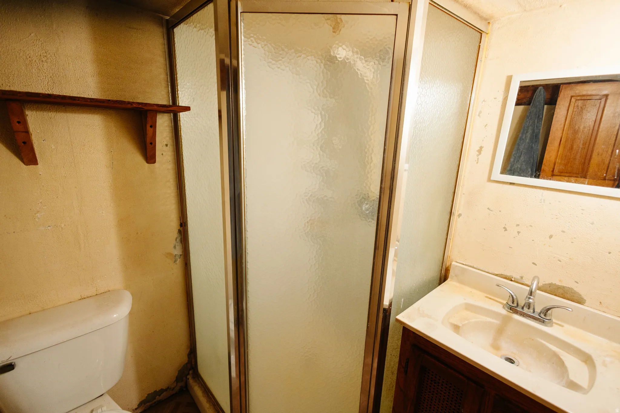 Full bathroom with vanity, a shower stall, and a textured wall