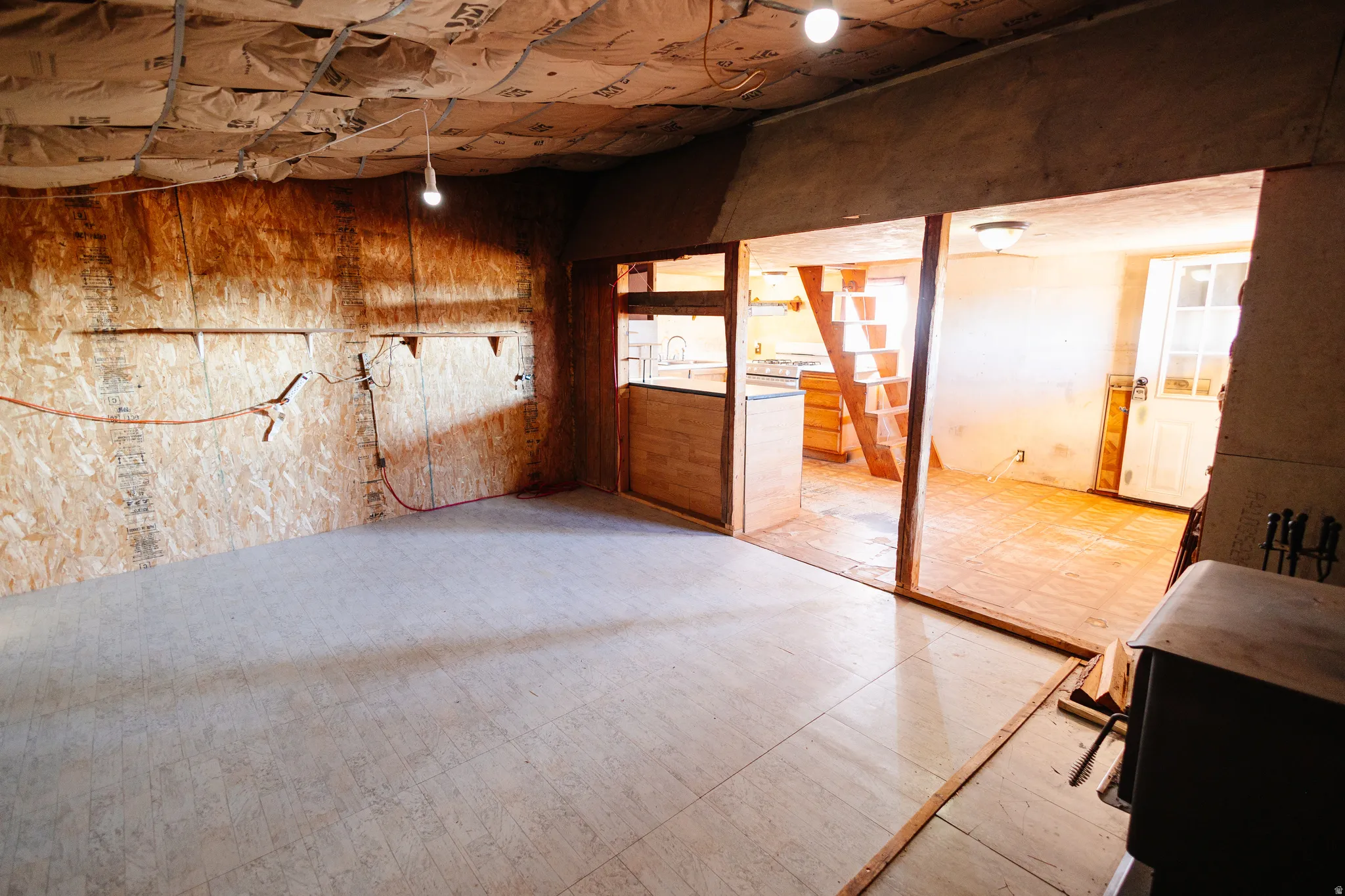 Unfinished tile patterned floors and wooden walls