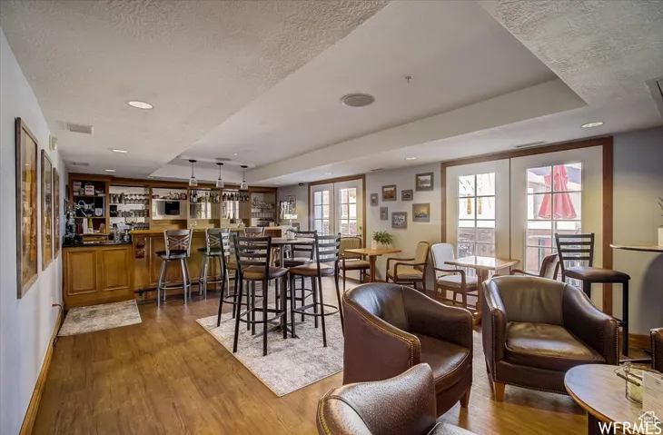 Dining area with a wealth of natural light, hardwood / wood-style floors, and a textured ceiling