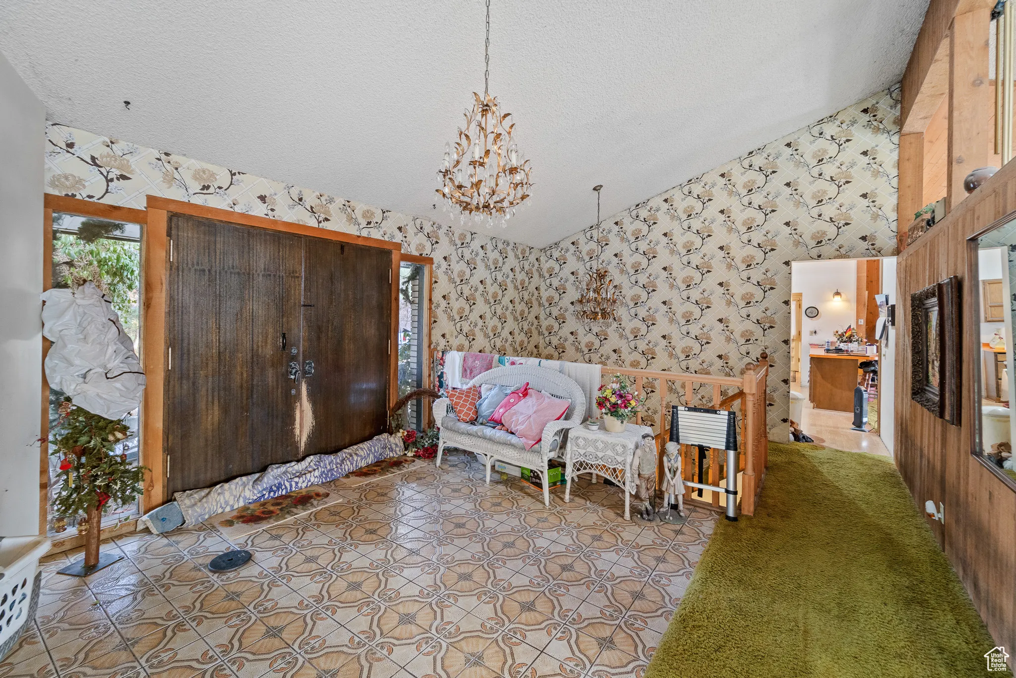 Unfurnished room featuring lofted ceiling, a textured ceiling, and an inviting chandelier