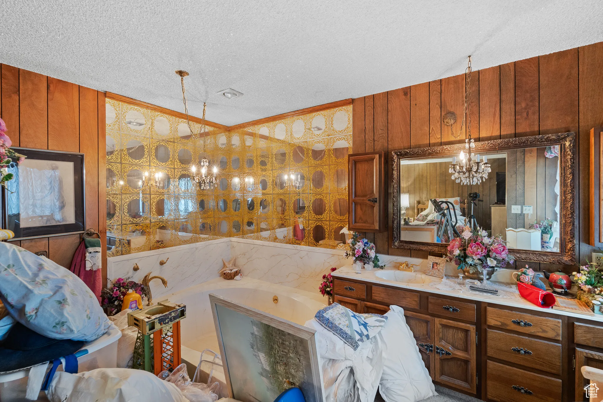 Bathroom with vanity, a textured ceiling, a chandelier, and wooden walls