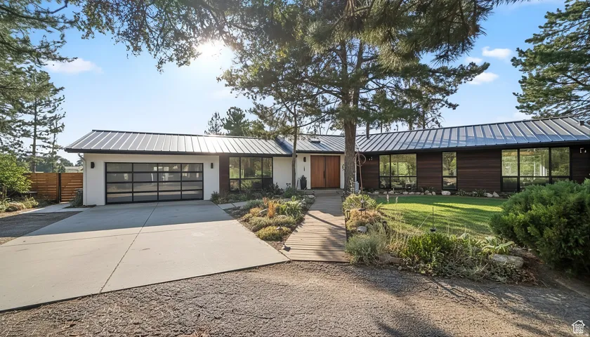 This is a rendering. View of front of home featuring driveway, a standing seam roof, a garage, and a front yard
