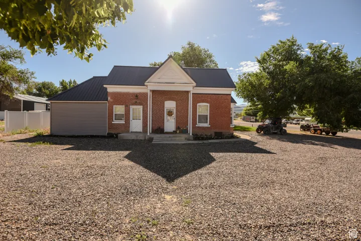 Greek revival inspired property featuring brick siding and a metal roof