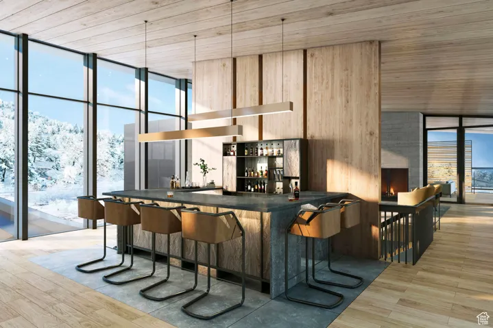 Bar with light brown cabinets, a wall of windows, wood ceiling, and light hardwood / wood-style flooring