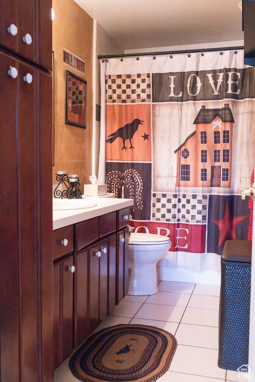 Bathroom with vanity, toilet, tile walls, and curtained shower