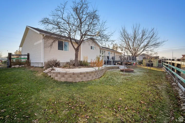 Rear view of property with a lawn and a wooden deck