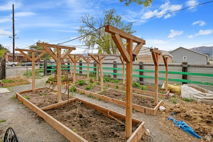View of play area featuring a vegetable garden and fence