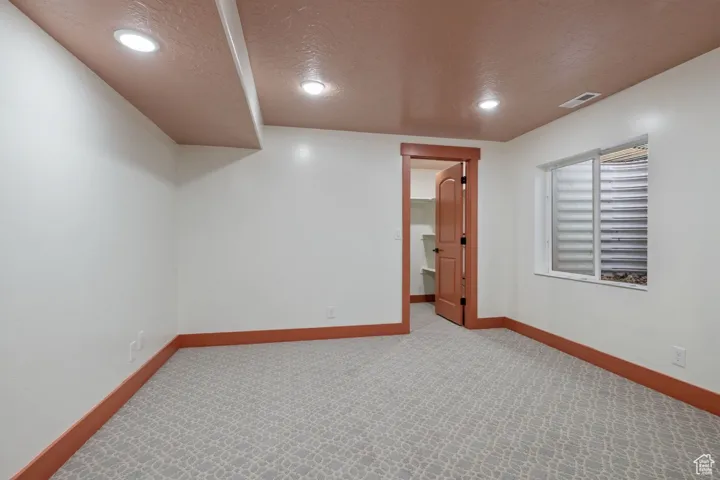 Unfurnished room featuring baseboards, visible vents, a textured ceiling, and carpet flooring