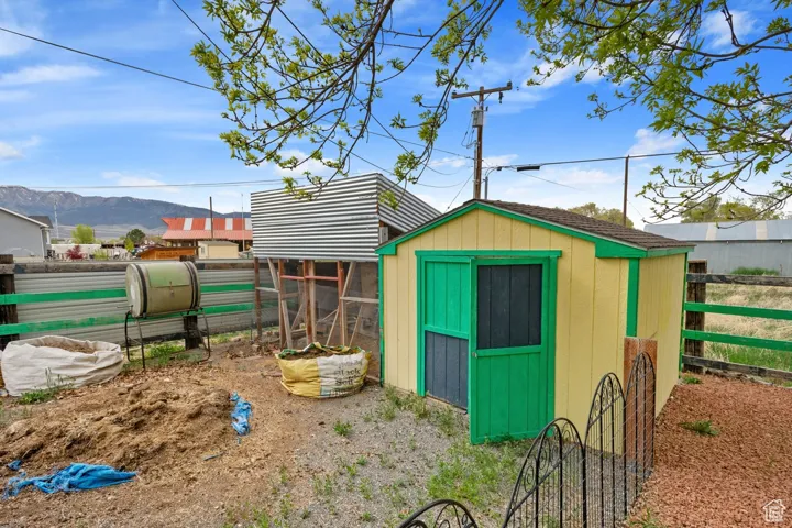 View of shed featuring a mountain view, exterior structure, and fence