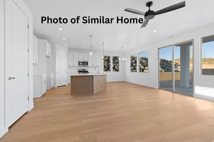 Dual tone kitchen with suspended lighting, an island with sink, light wood finished floors, a ceiling fan, and open floor plan