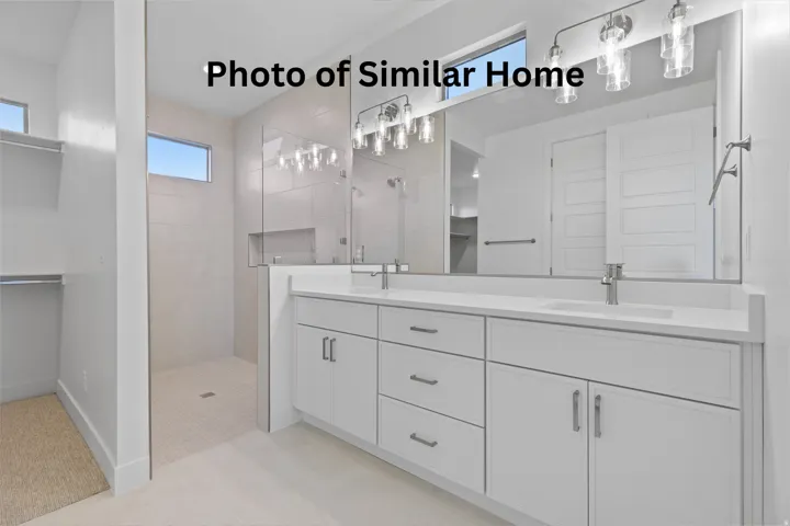Bathroom featuring a spacious closet, double vanity, walk in shower, and light tile patterned flooring