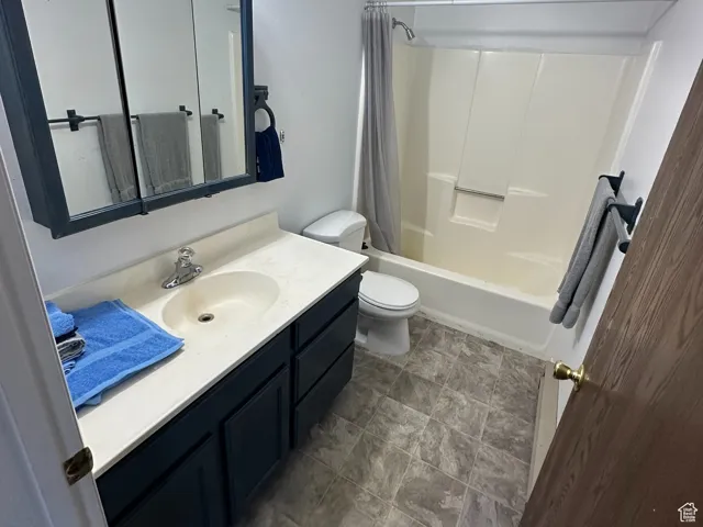 Full bathroom with shower / bath combination with curtain, toilet, and vanity