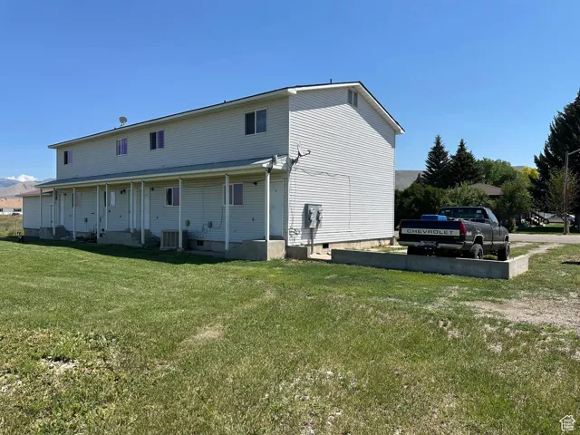 Rear view of property featuring a lawn and crawl space