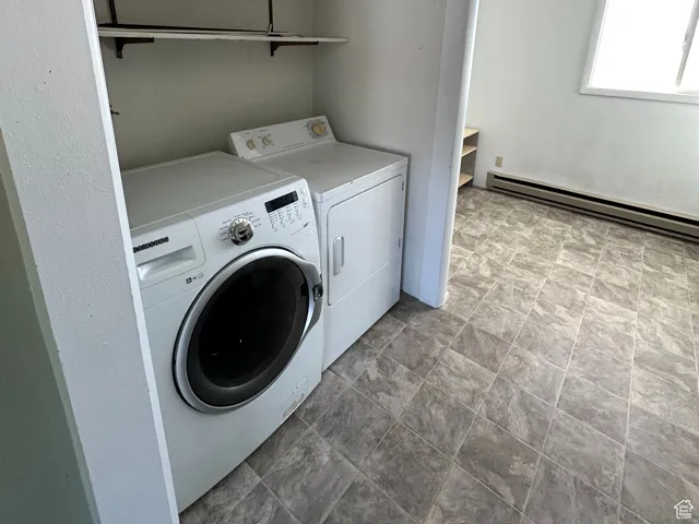 Laundry area featuring a baseboard radiator and washer and clothes dryer