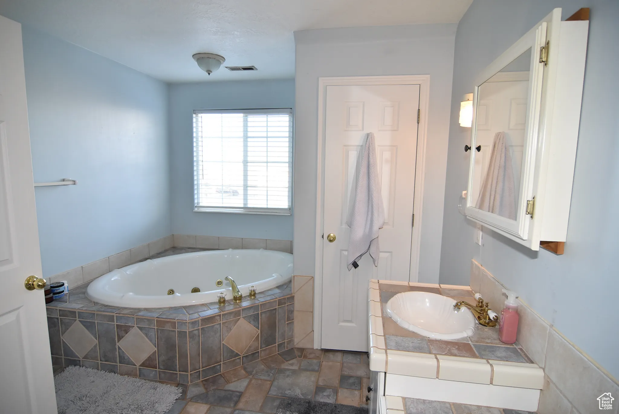 Bathroom with vanity and a relaxing tiled tub