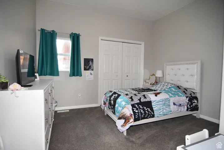 Bedroom featuring a closet and dark colored carpet