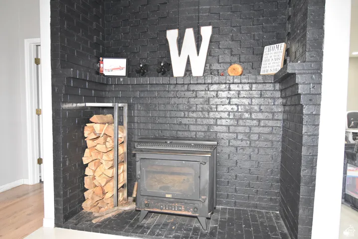Room details with hardwood / wood-style flooring and a wood stove