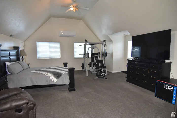 Bedroom featuring carpet floors, a wall mounted AC, lofted ceiling, and ceiling fan
