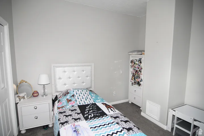 Bedroom featuring dark colored carpet