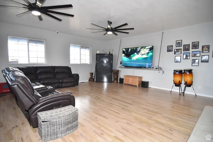 Living room with hardwood / wood-style floors, a textured ceiling, and ceiling fan