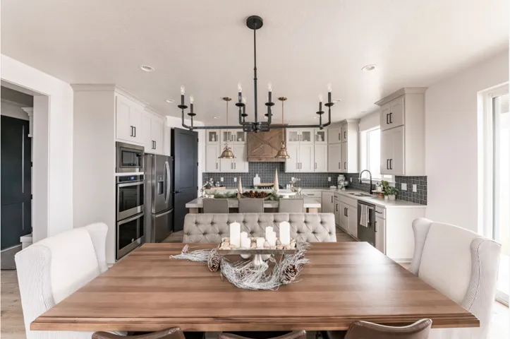 Open-concept dining area featuring a wood-finish table and a contemporary black chandelier