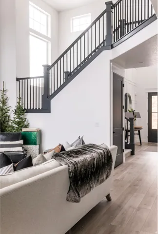 Two-story foyer with a dark-finished staircase featuring white risers and a matching upper-level railing