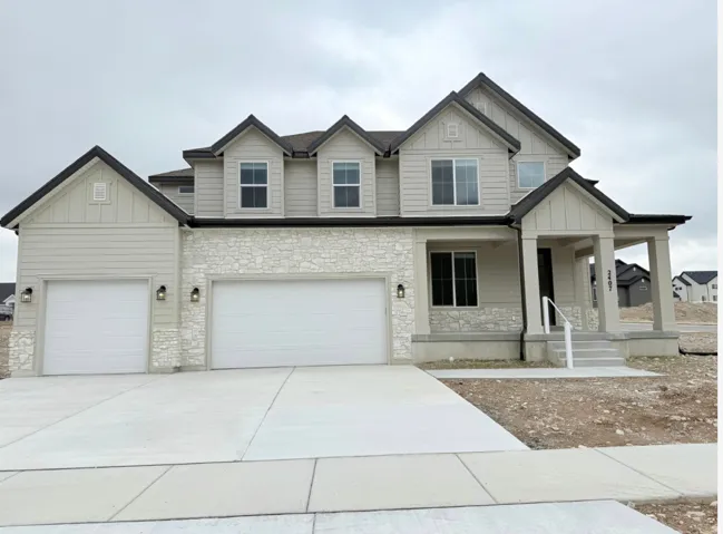 Contemporary two-story residence featuring light siding and stone veneer accents