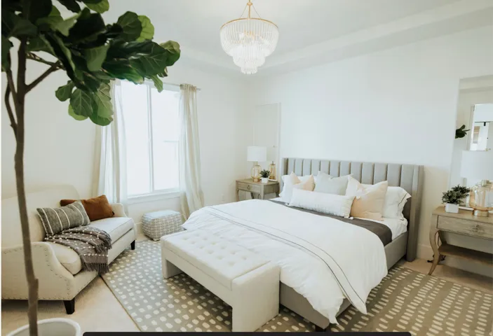 Carpeted bedroom featuring a chandelier and a tray ceiling