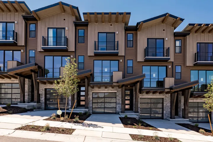 Townhome / multi-family property featuring board and batten siding, stone siding, an attached garage, and a mountain view