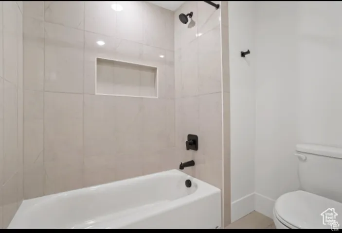 Bathroom featuring toilet and tiled shower / bath