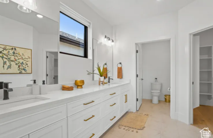 Bathroom with toilet, vanity, and tile patterned flooring