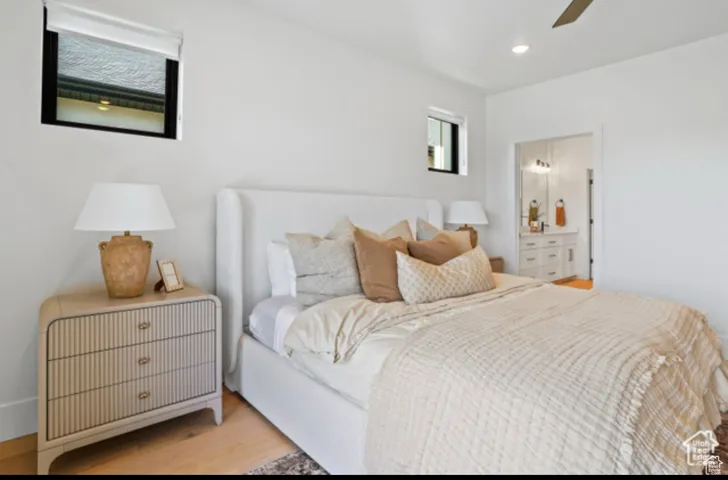 Bedroom with connected bathroom, ceiling fan, and light hardwood / wood-style flooring