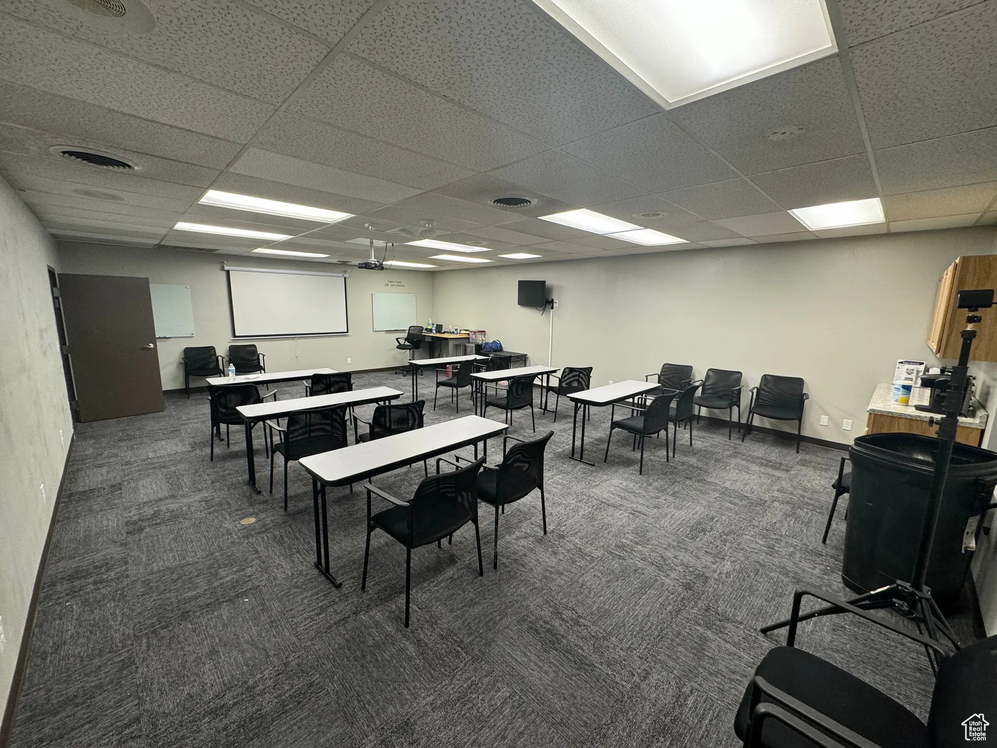 Carpeted dining space featuring a paneled ceiling