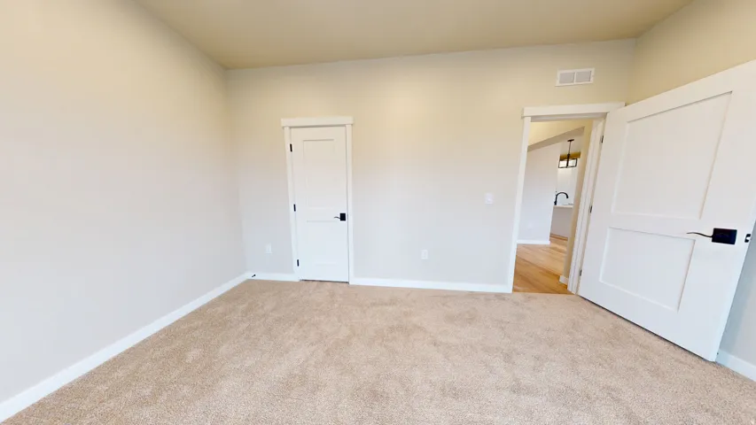 Unfurnished bedroom with baseboards and light carpet