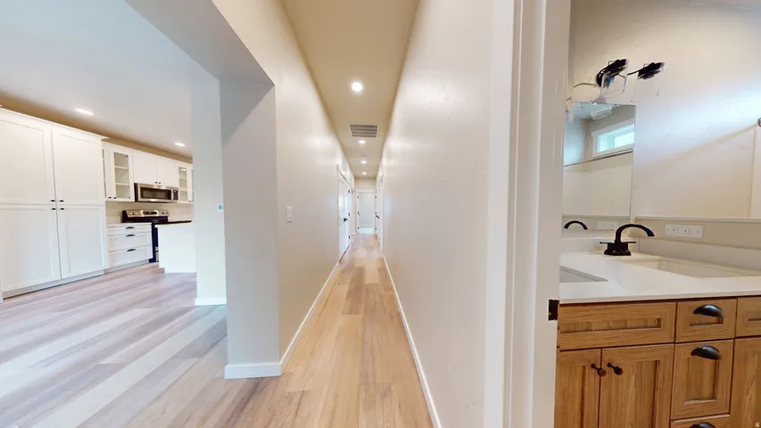 Hall featuring light wood-style floors and recessed lighting
