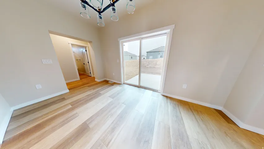 Unfurnished dining area featuring a chandelier and light wood-style floors