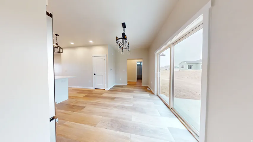 Hall featuring recessed lighting, light wood-style floors, and a chandelier