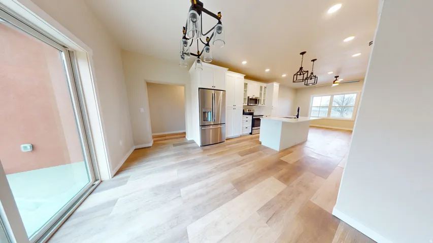 Kitchen featuring white cabinets, recessed lighting, stainless steel appliances, light wood-style flooring, and hanging light fixtures