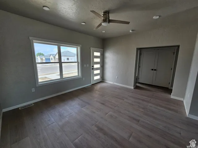 Spare room with ceiling fan, a textured ceiling, and light wood-type flooring
